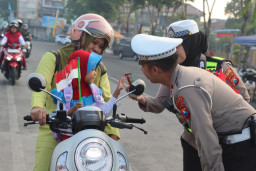 Sambut HUT RI ke-81, Satlantas Polres Sampang Bagikan Bendera di Simpang Empat Monumen